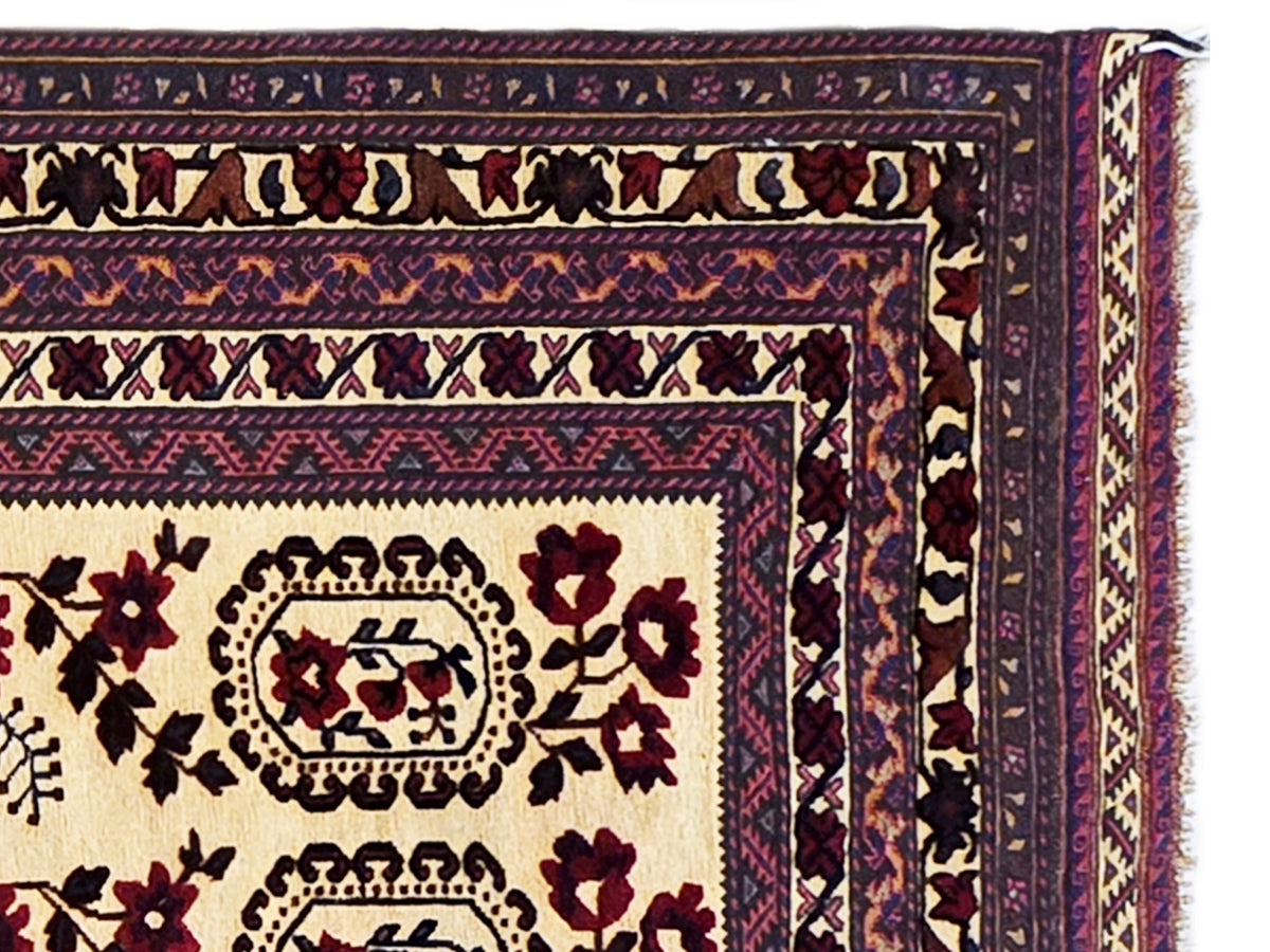 Close-up of area rug border with dark navy vines, cream ground, and burgundy accents.