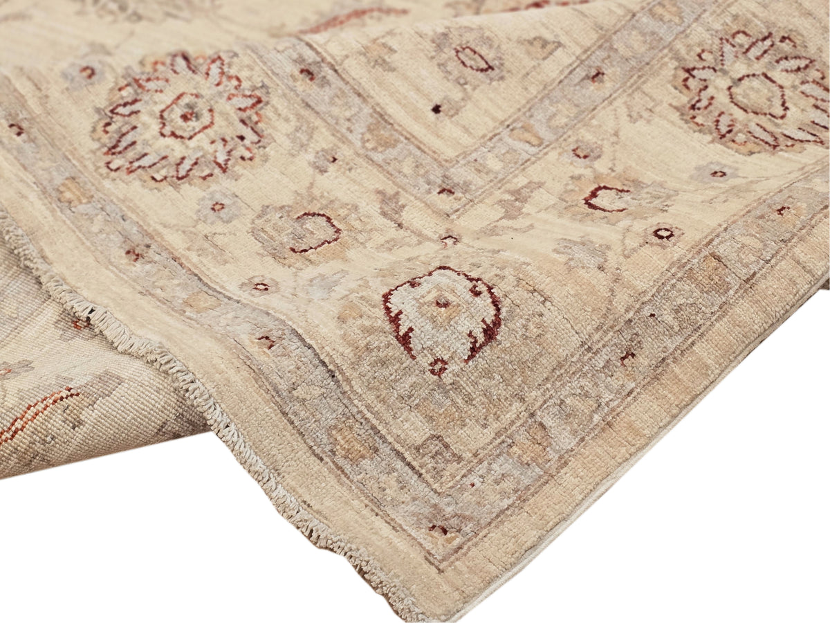 Afghan rug with cream, red medallions, and short fringe along one edge