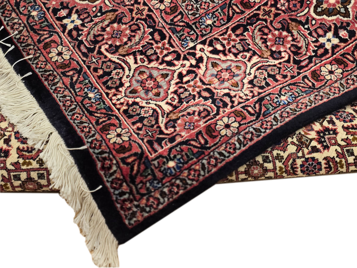 Bidjar rug corner detail with red floral pattern and cream fringes