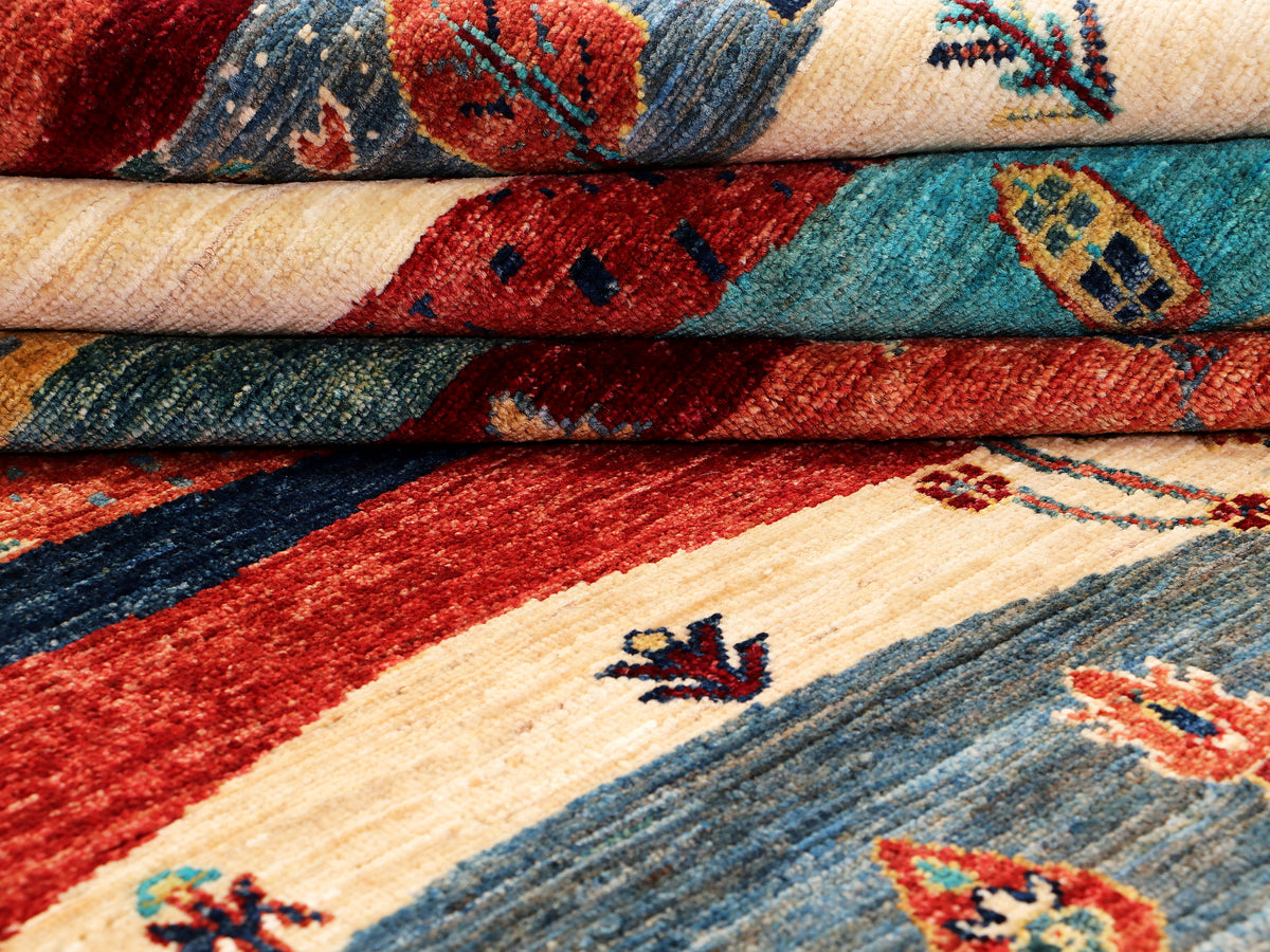 Ariana Gabbeh rug rolled layers showing multicolor bands and textured weave.