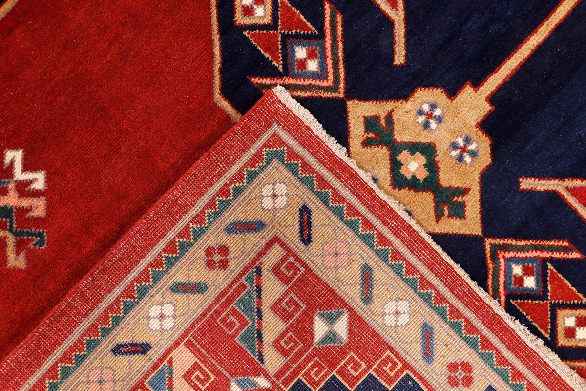 Red rug corner with navy, cream, and multicolor geometric star and diamond shapes