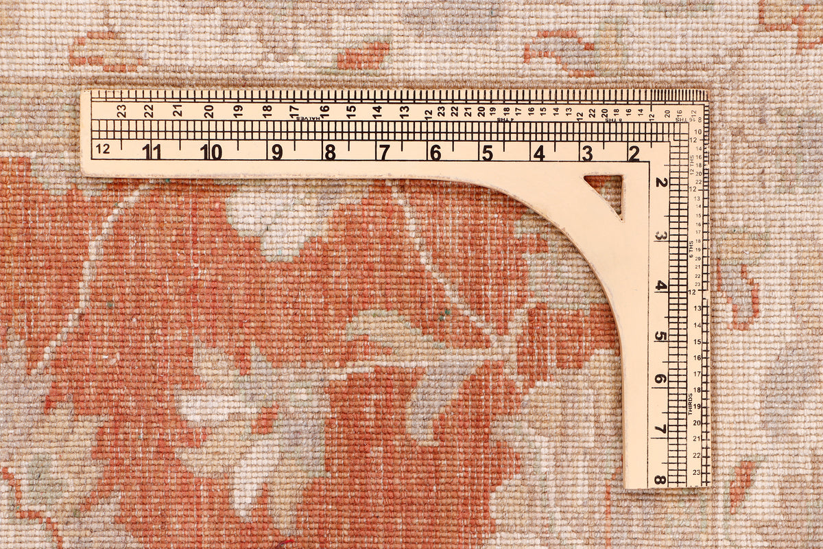 Terracotta and cream rug edge with measuring tape laid across the fabric.