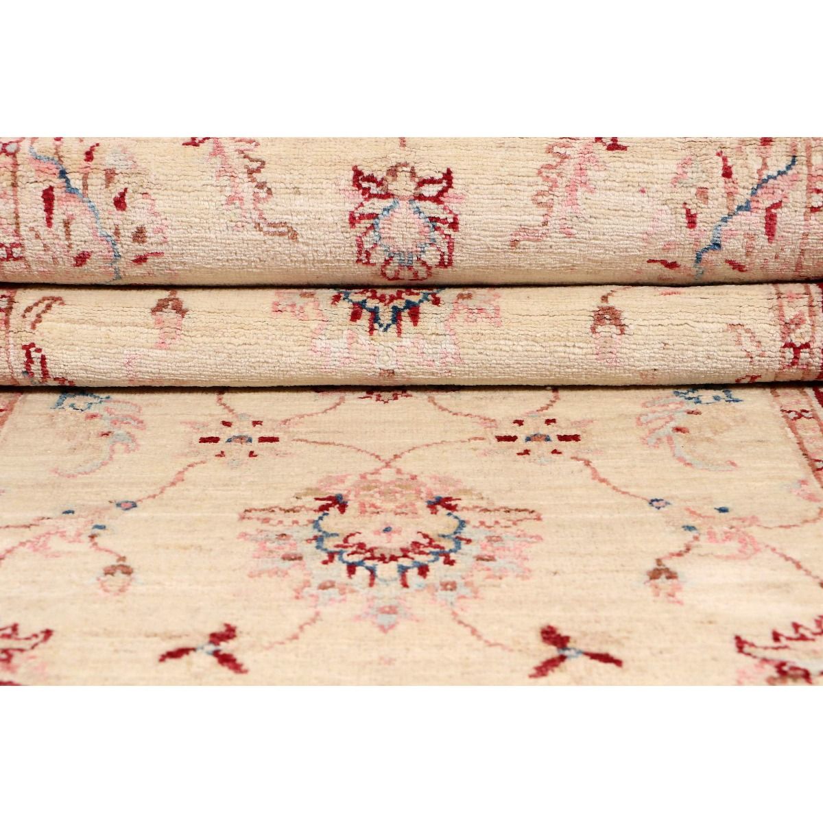 Cream rug pile close-up with red and blue floral pattern lines.