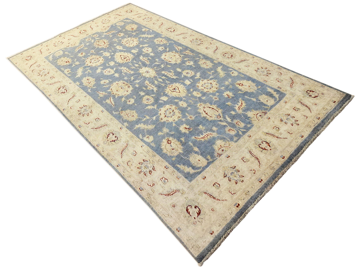 Afghan rug top view with cream border, blue field, and central floral medallion