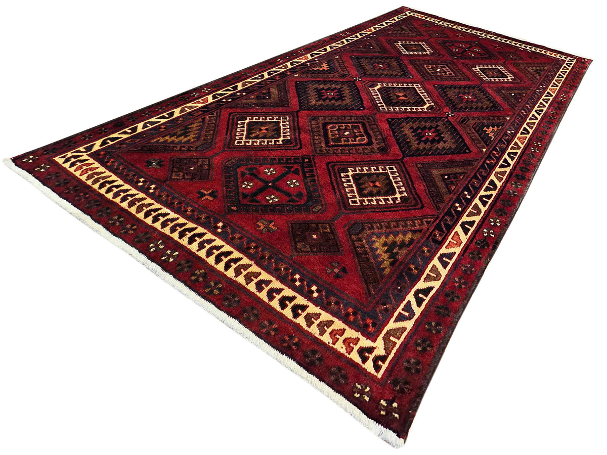 Red and navy geometric area rug with cream border and repeating square patterns