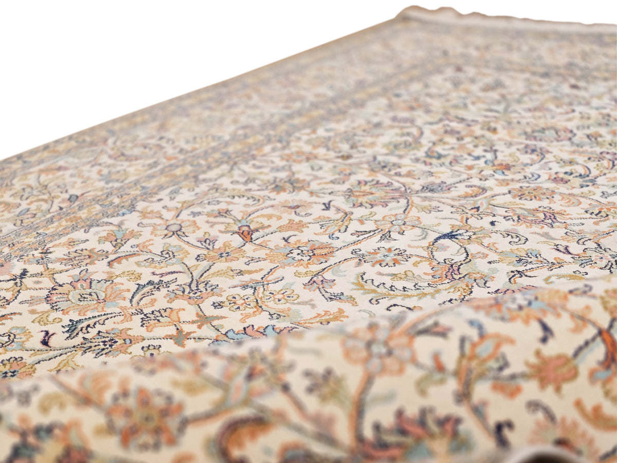 Beige silk rug close-up with dense floral ornament and fine border detailing