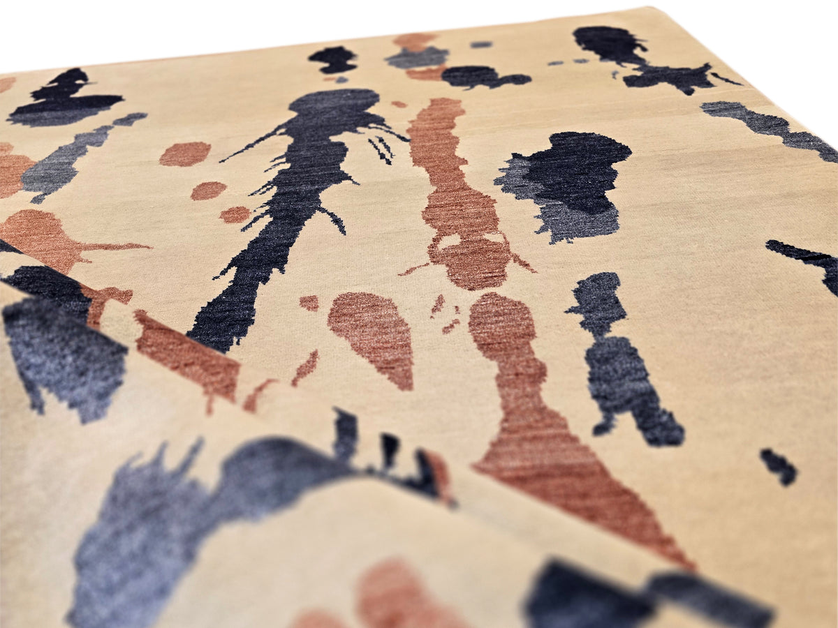 Close-up of beige rug with textured blue and rust abstract pattern