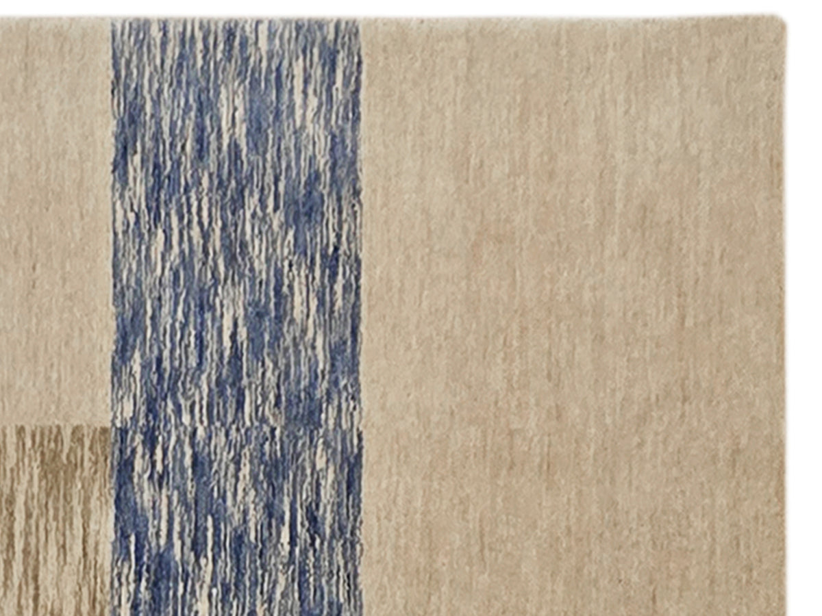 Corner view of beige and blue handloom rug with textured stripe section