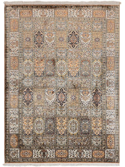 Silk rug with repeating medallions and border, blue and rust tones, fringed edges.