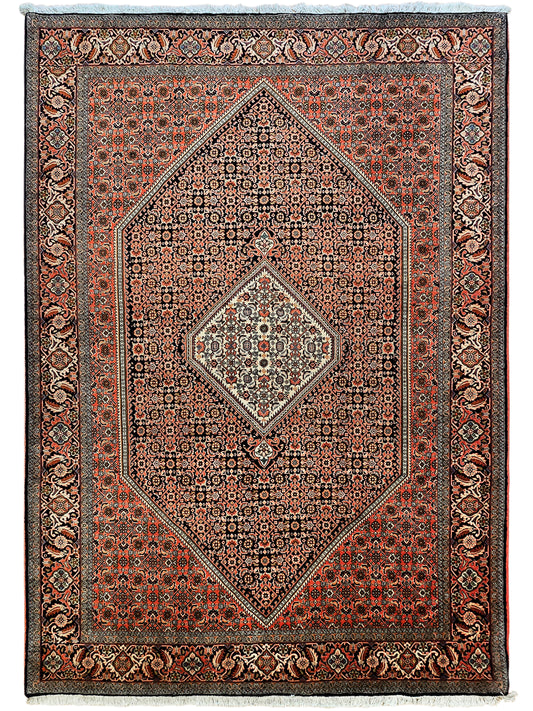 Ornate rust, black and cream area rug with central diamond medallion and bordered design.