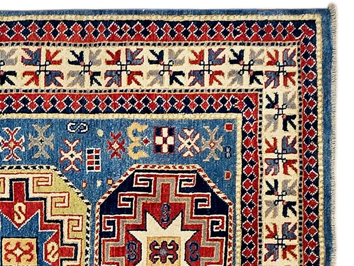 Kazak rug close-up border with blue, red, and beige lattice patterns.