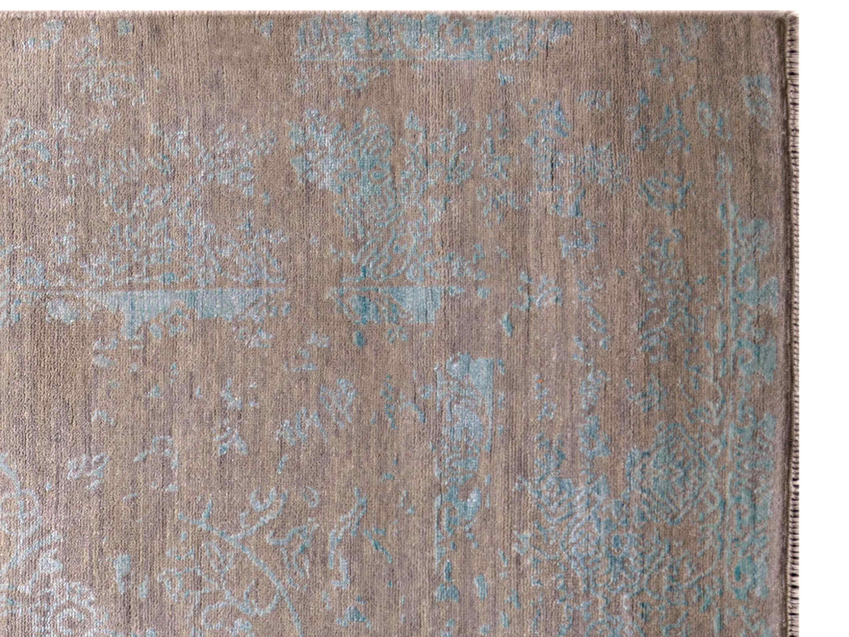 Close-up of modern rug texture with tan surface and scattered muted blue pattern details