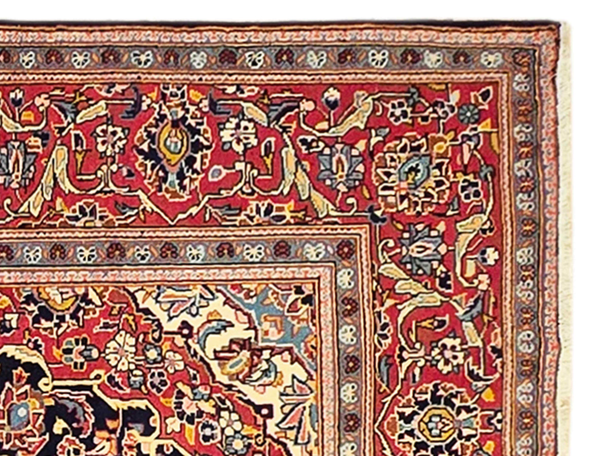 Red and navy ornate Persian-style rug with geometric border and medallion center.