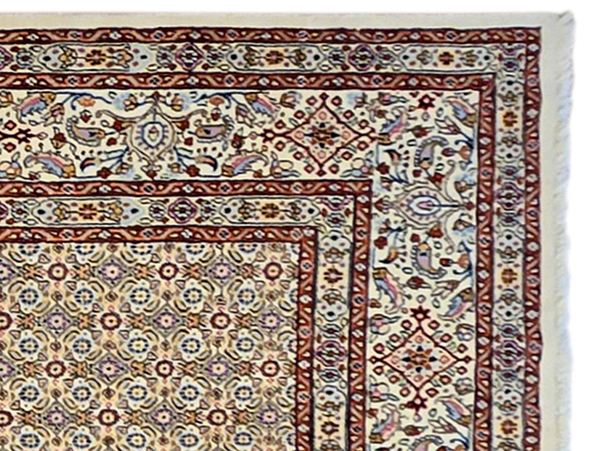 Persian rug border close-up with ornate vine motifs in rust, navy, and cream tones