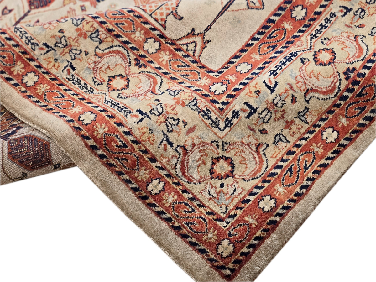 Corner detail of rectangular rug with cream, rust, navy geometric vines