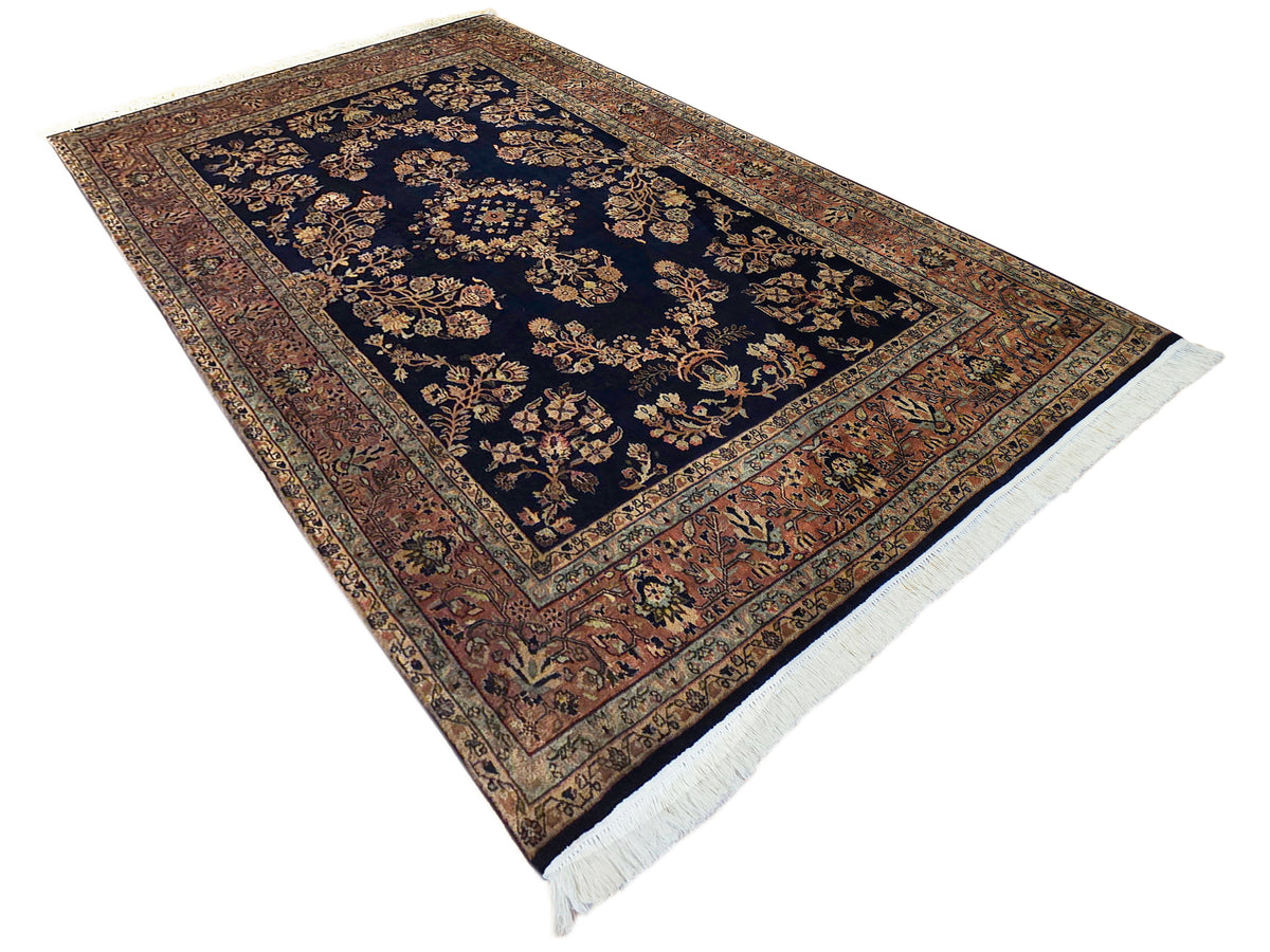 Sarouk rug in dark navy with large geometric medallion, rust border, short fringes