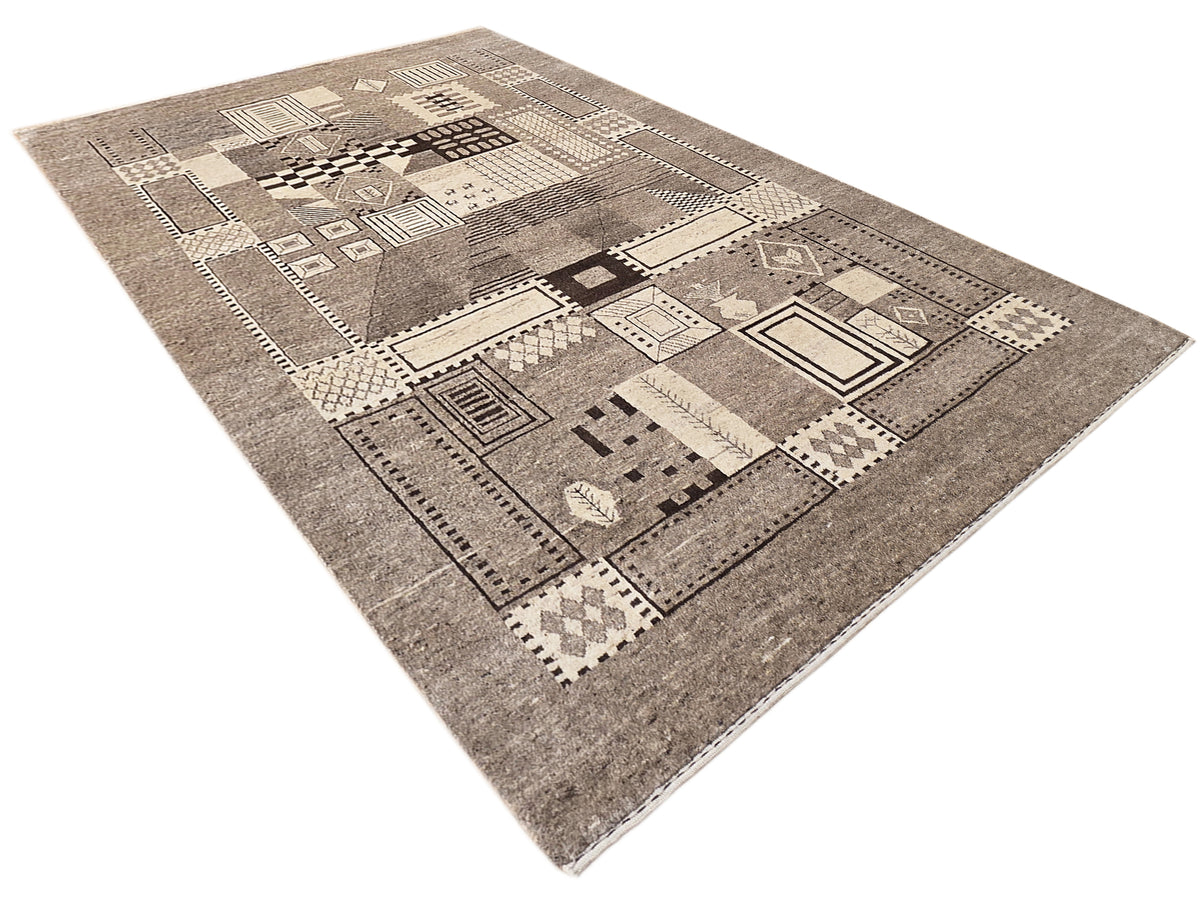 Diagonal view of geometric patchwork rug in gray, beige, and dark accents