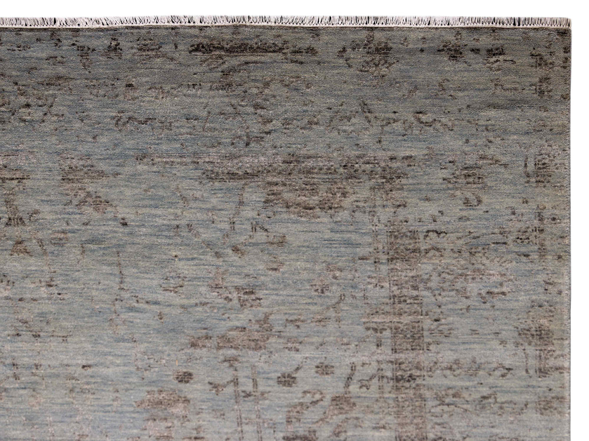 Light gray distressed rug close-up with textured pattern and fringed edge