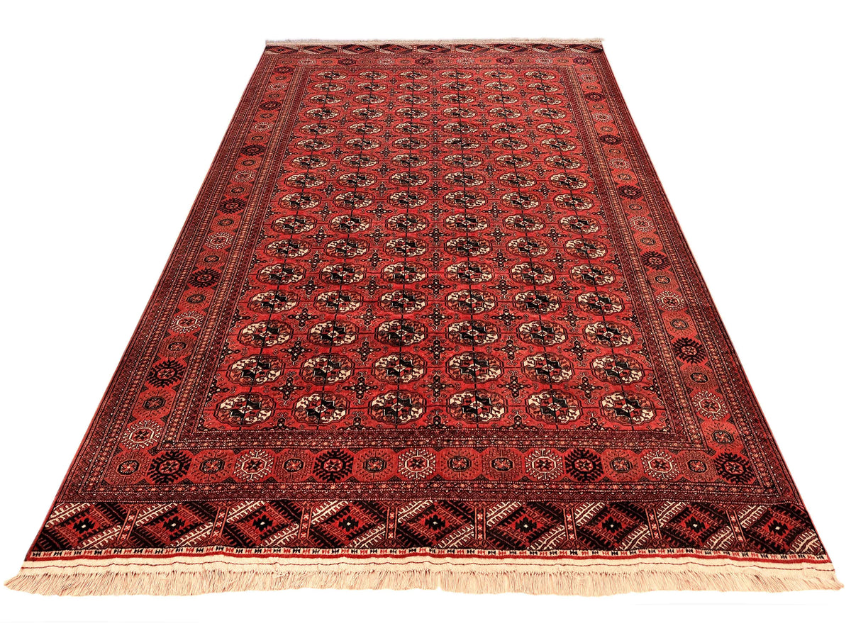 Red patterned rug with central field of medallions and fringed edge border