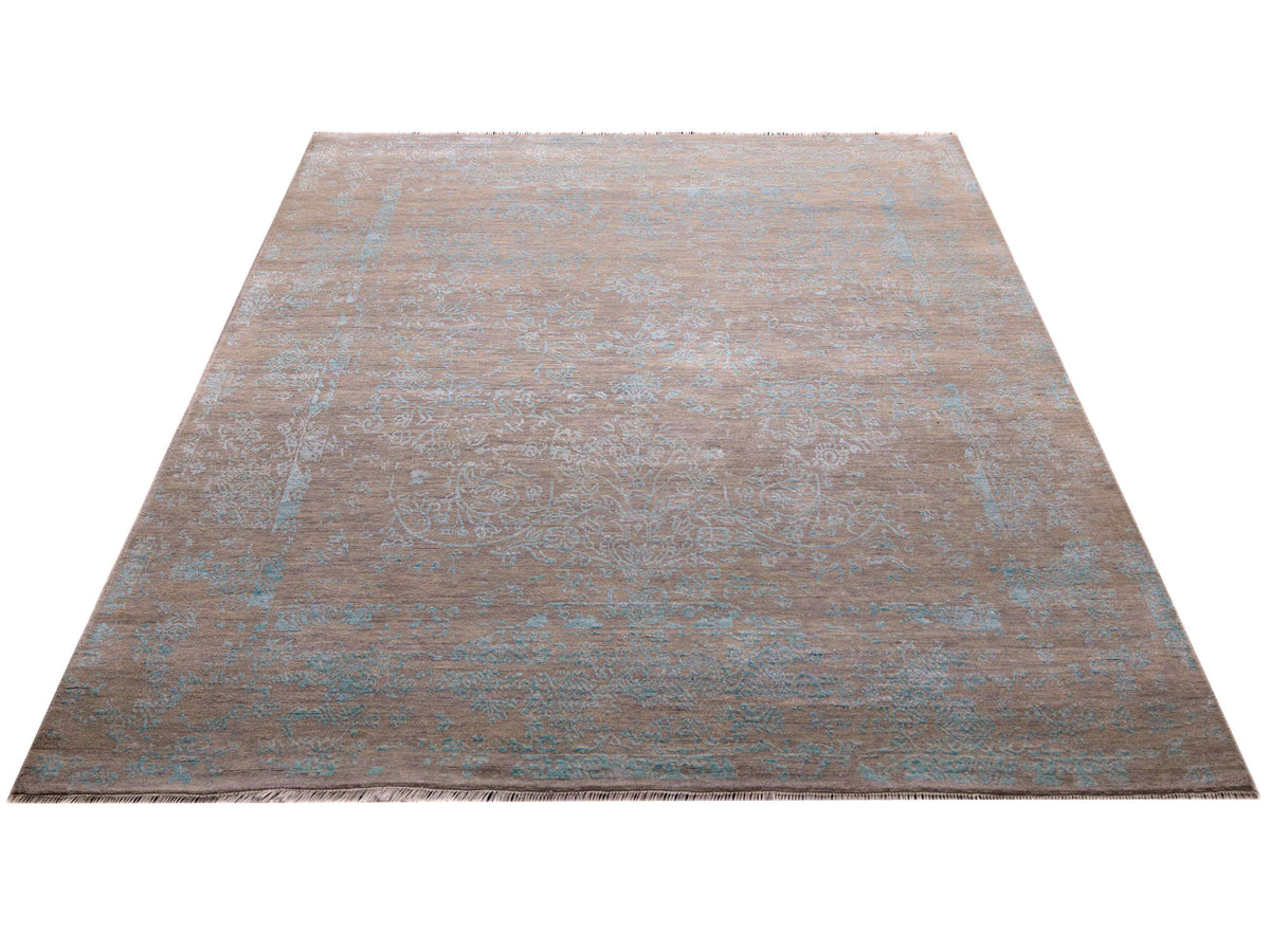 Rectangular modern area rug with distressed pattern in tan and muted blue tones