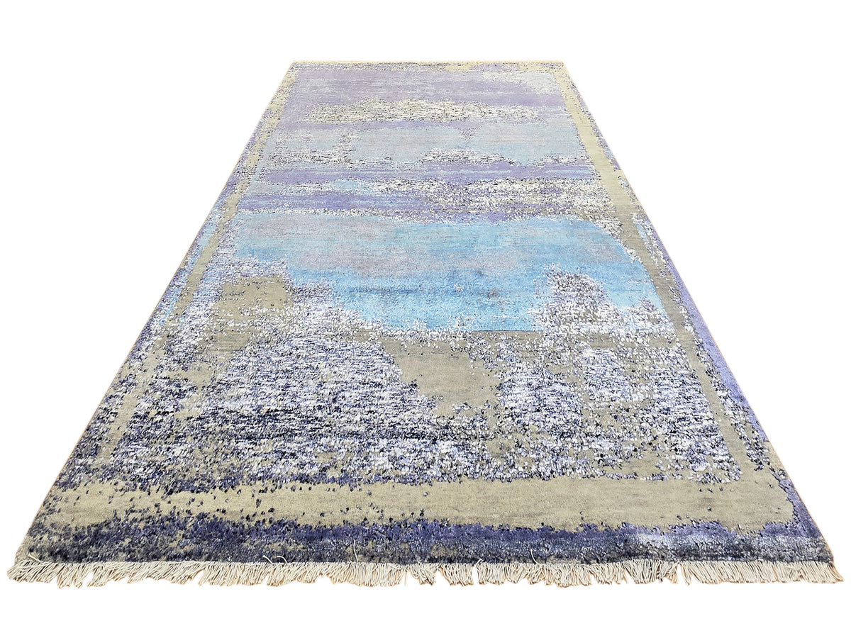 Abstract area rug in blue, beige, and violet with short fringe border
