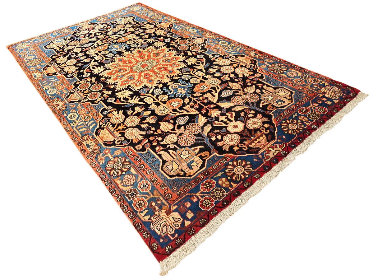 Nahawaand rug, orange border with black center, detailed geometric and floral pattern, fringed.