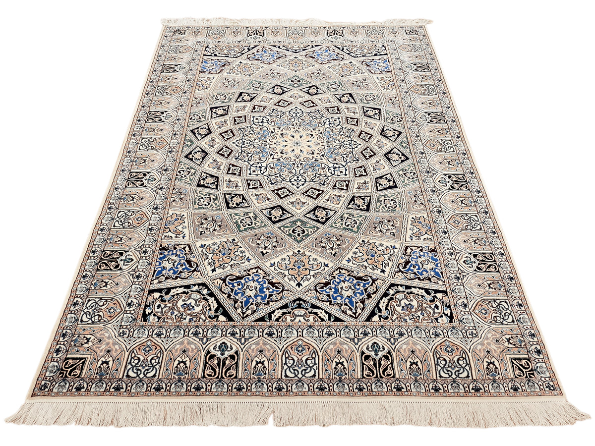 Beige and blue ornate area rug with central medallion, scrolling border, and fringe trim.