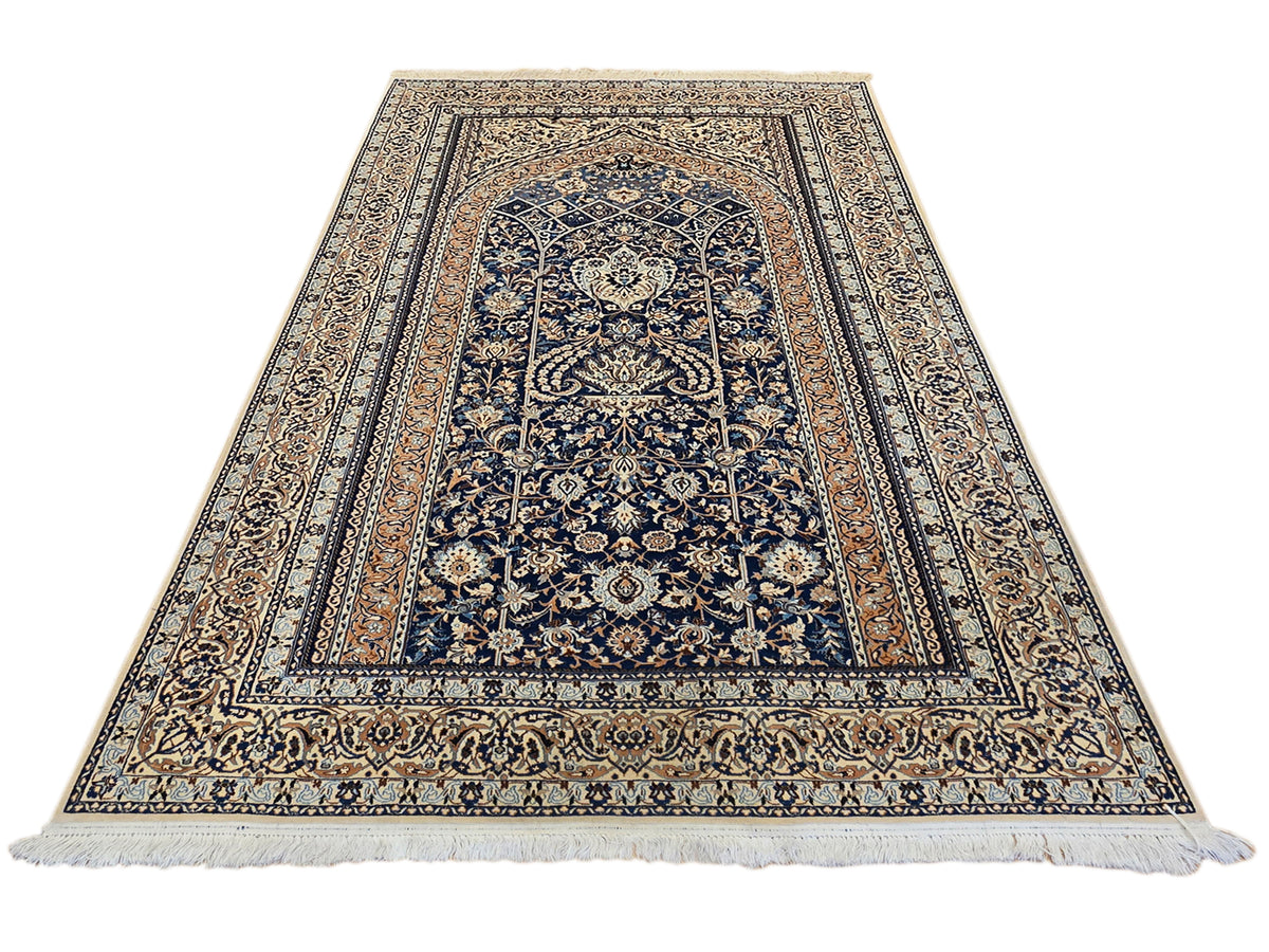 Blue and cream patterned area rug with arch motif and fringed ends