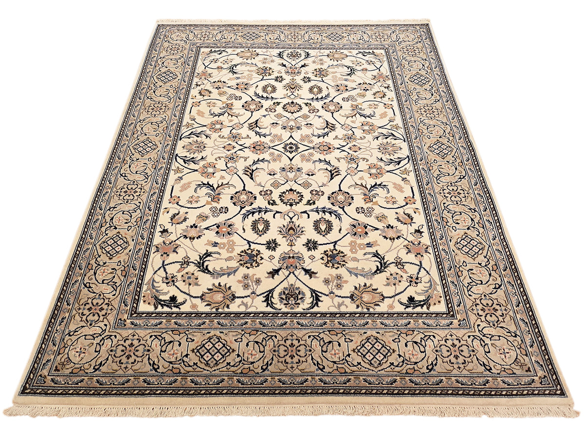 Nain rug with cream background, dark blue frame border, and dense floral pattern, fringed hem