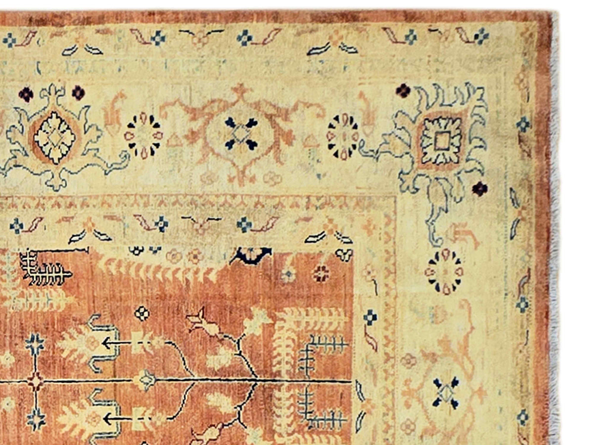 Close-up of orange and cream rug design with floral and geometric motifs