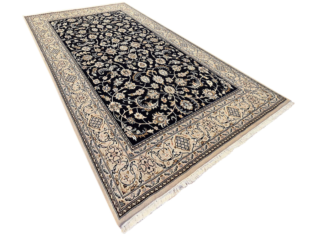 Navy Nain rug with detailed cream border and central floral medallion, fringed corners