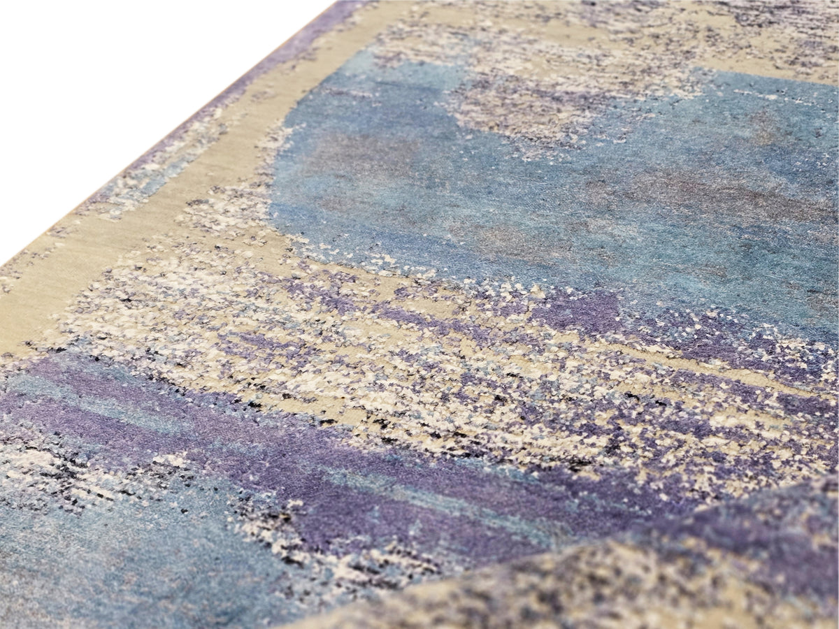 Abstract area rug with blue, beige, and violet distressed block pattern