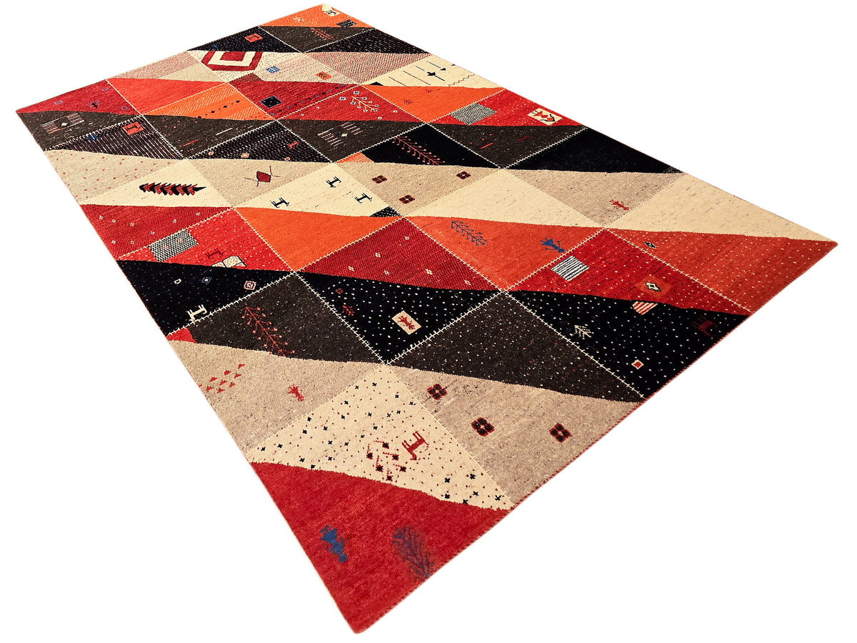 Patchwork Persian rug laid flat in red, black, and cream with geometric blocks