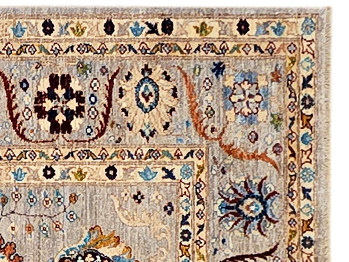 Close-up of light beige rug weave with blue, red, and navy floral shapes and border motifs
