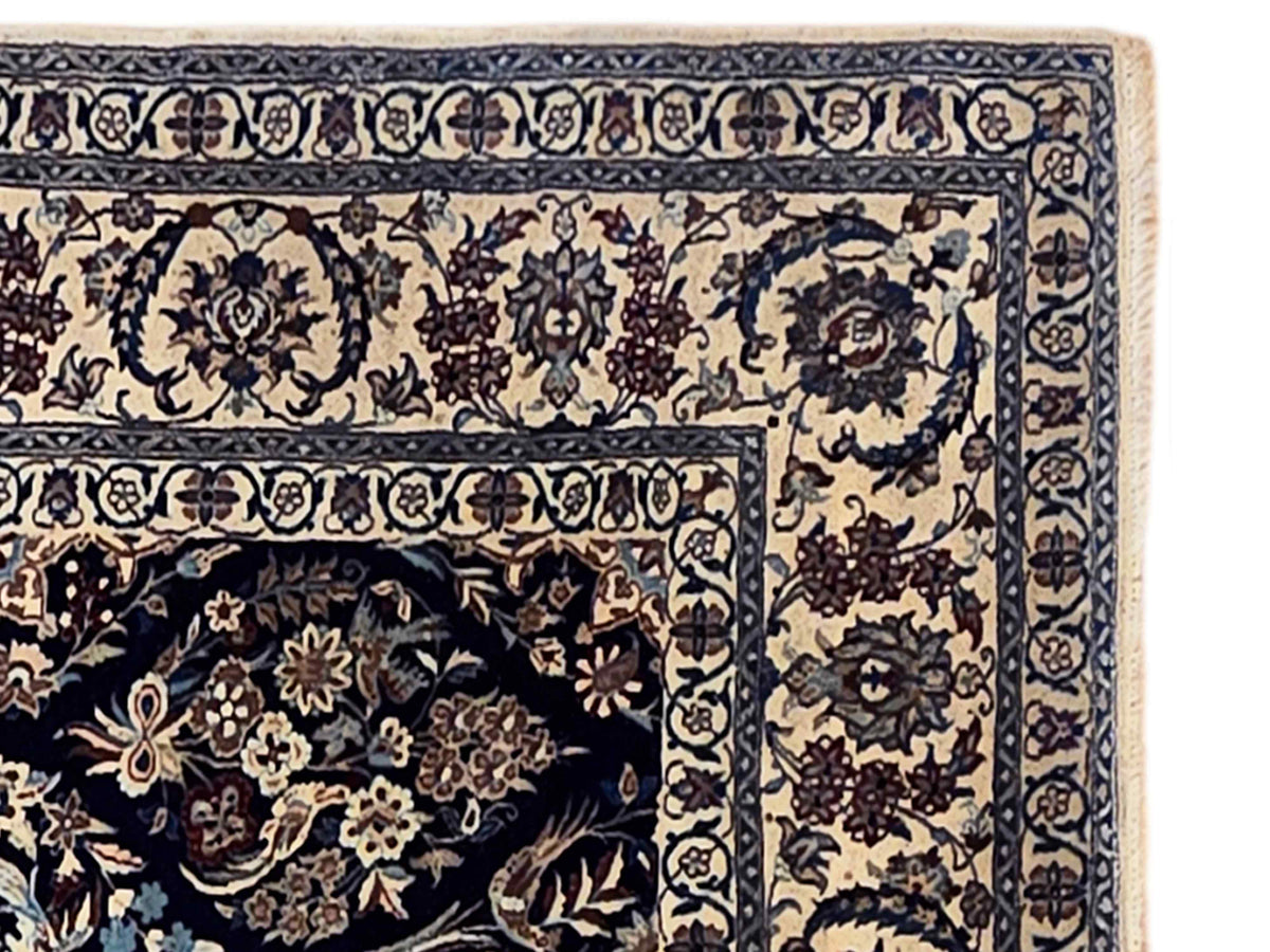 Rug border close-up in navy and cream with floral vines and scrollwork medallion