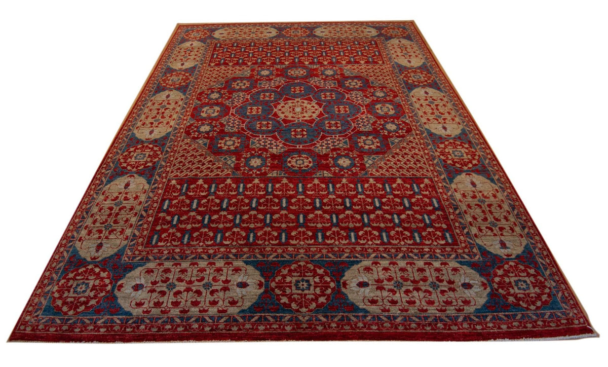 Red area rug with blue border, geometric motifs, and beige corner accents