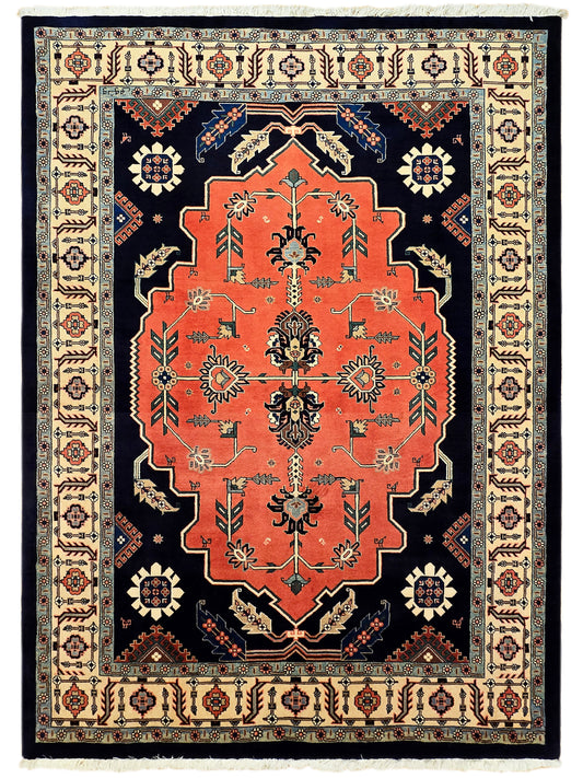 Fully framed rug with red central medallion on navy field and cream geometric border