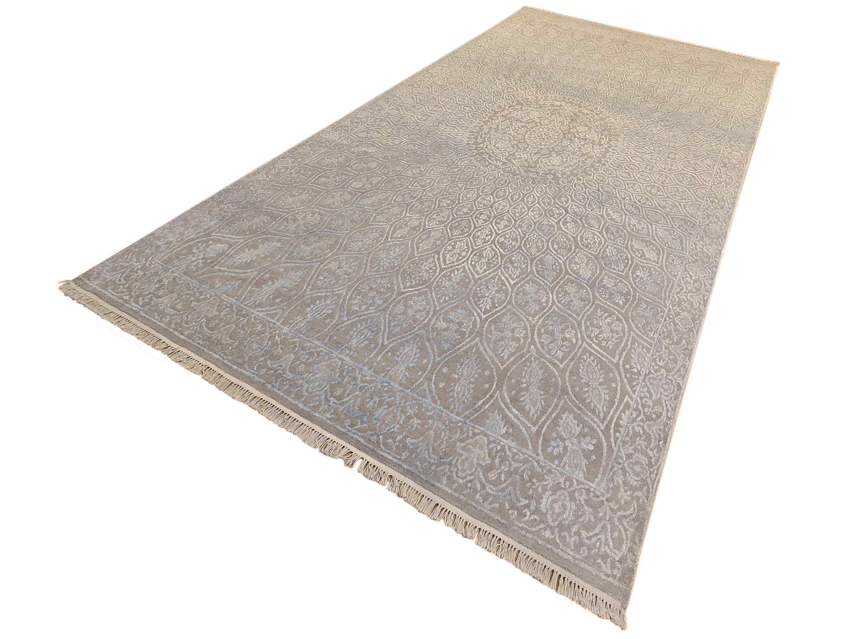 Rectangular light blue-gray rug with intricate damask-like motif and fringed edge.