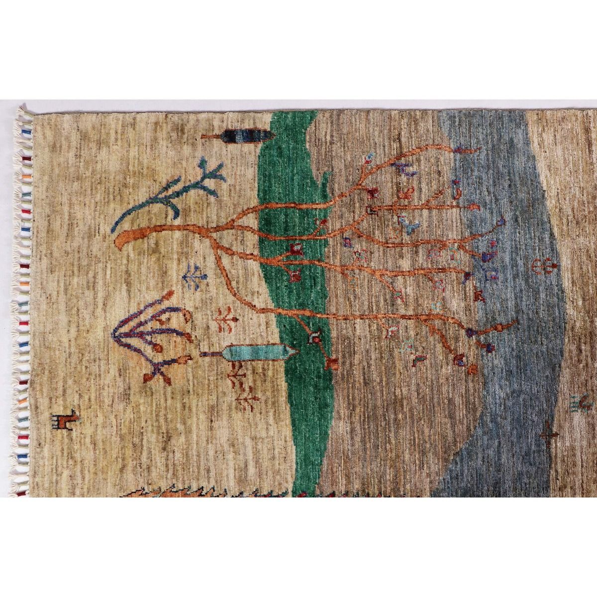 Ariana Gabbeh rug close-up with tan, blue, green vertical panel and trees