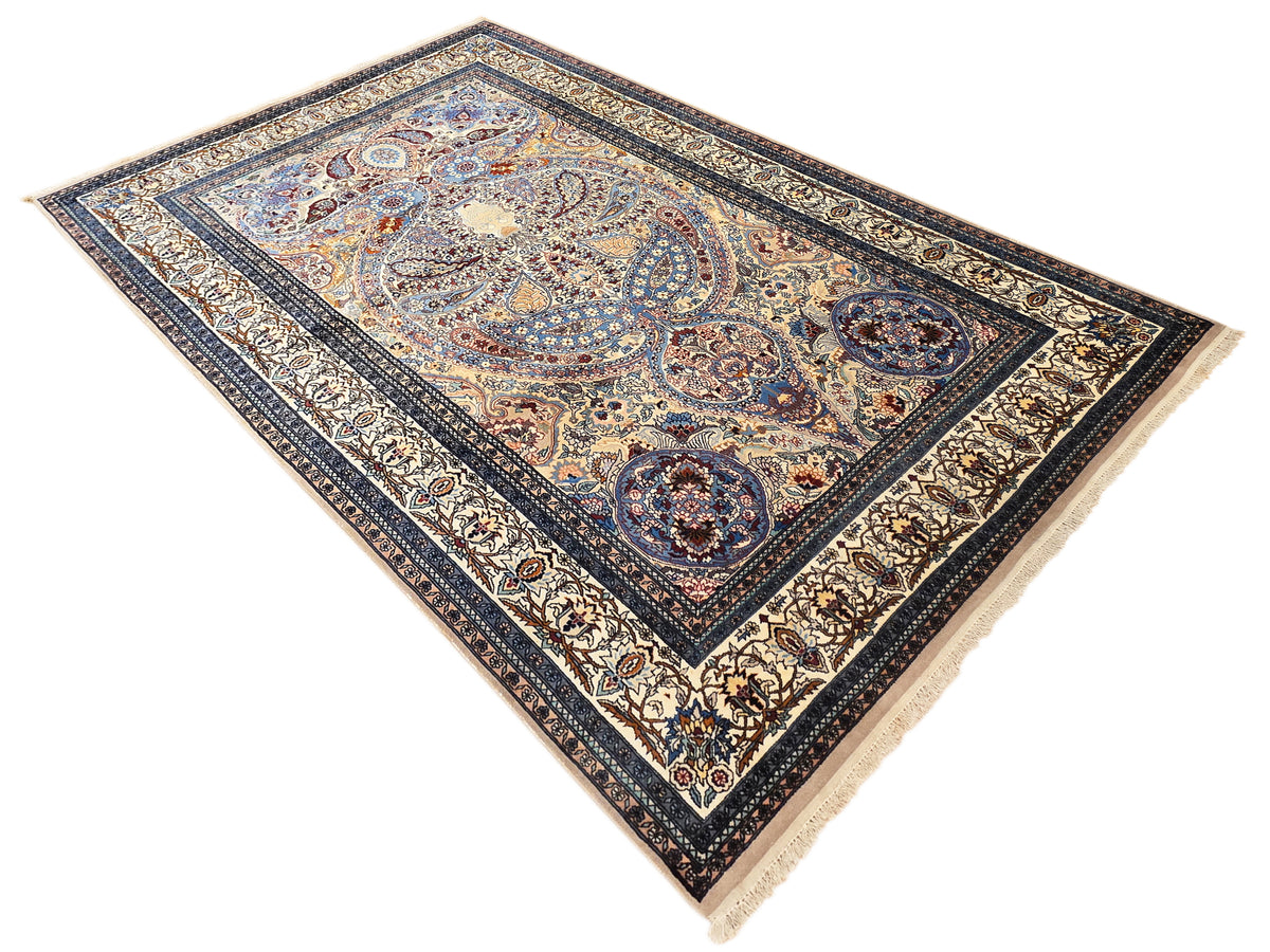 Blue Tabriz-style rectangular rug with central medallion, ornate border, and short fringes.