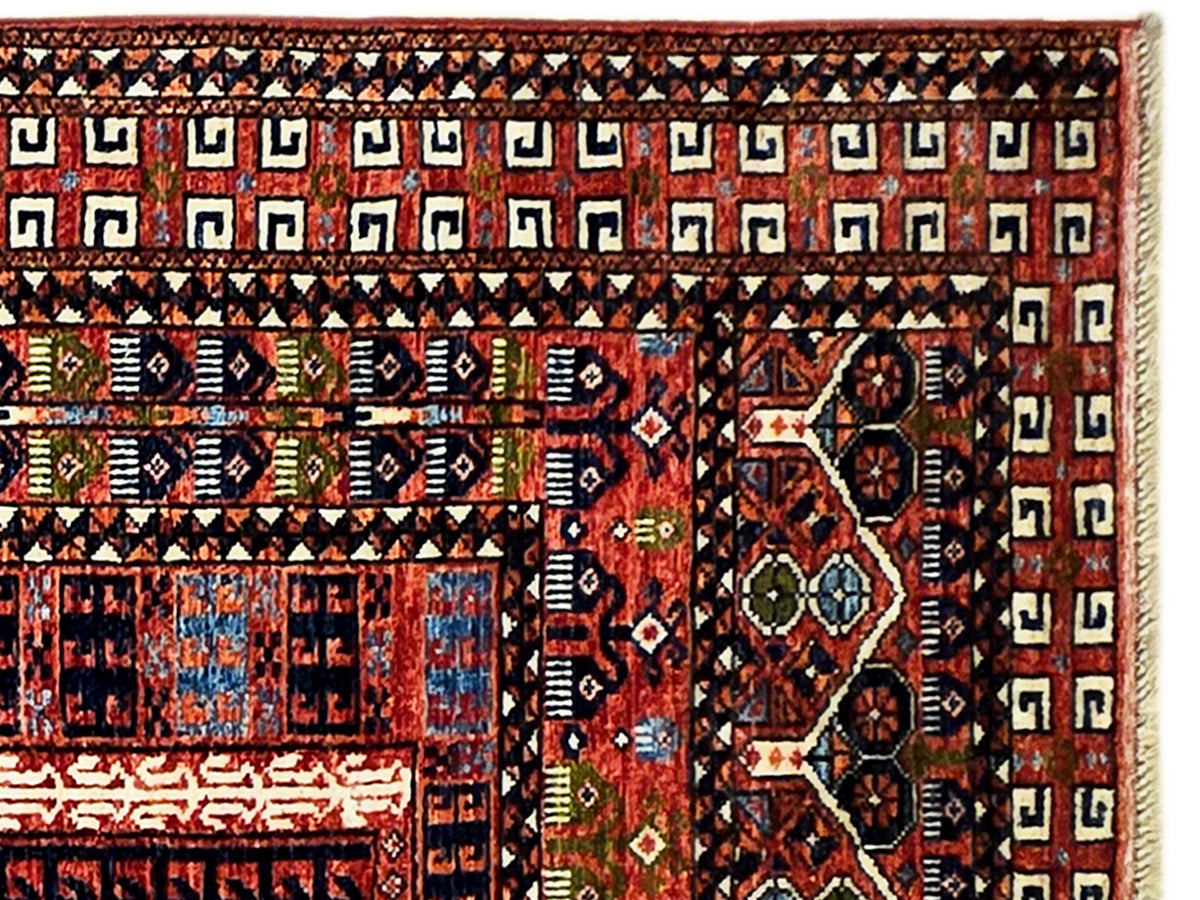 Close-up of a Turkmen-style rug border with red, black, navy, and beige motifs