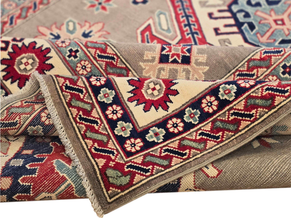 Kazak rug close-up weave with beige-gray base, red and blue pattern lines, and fringe