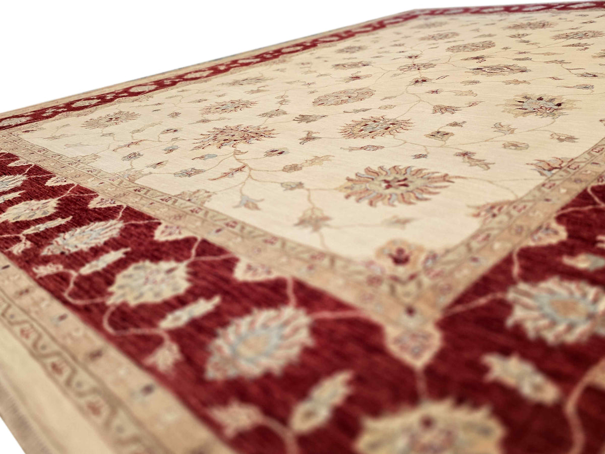 Cream and burgundy wool rug corner with floral pattern and short pile detail