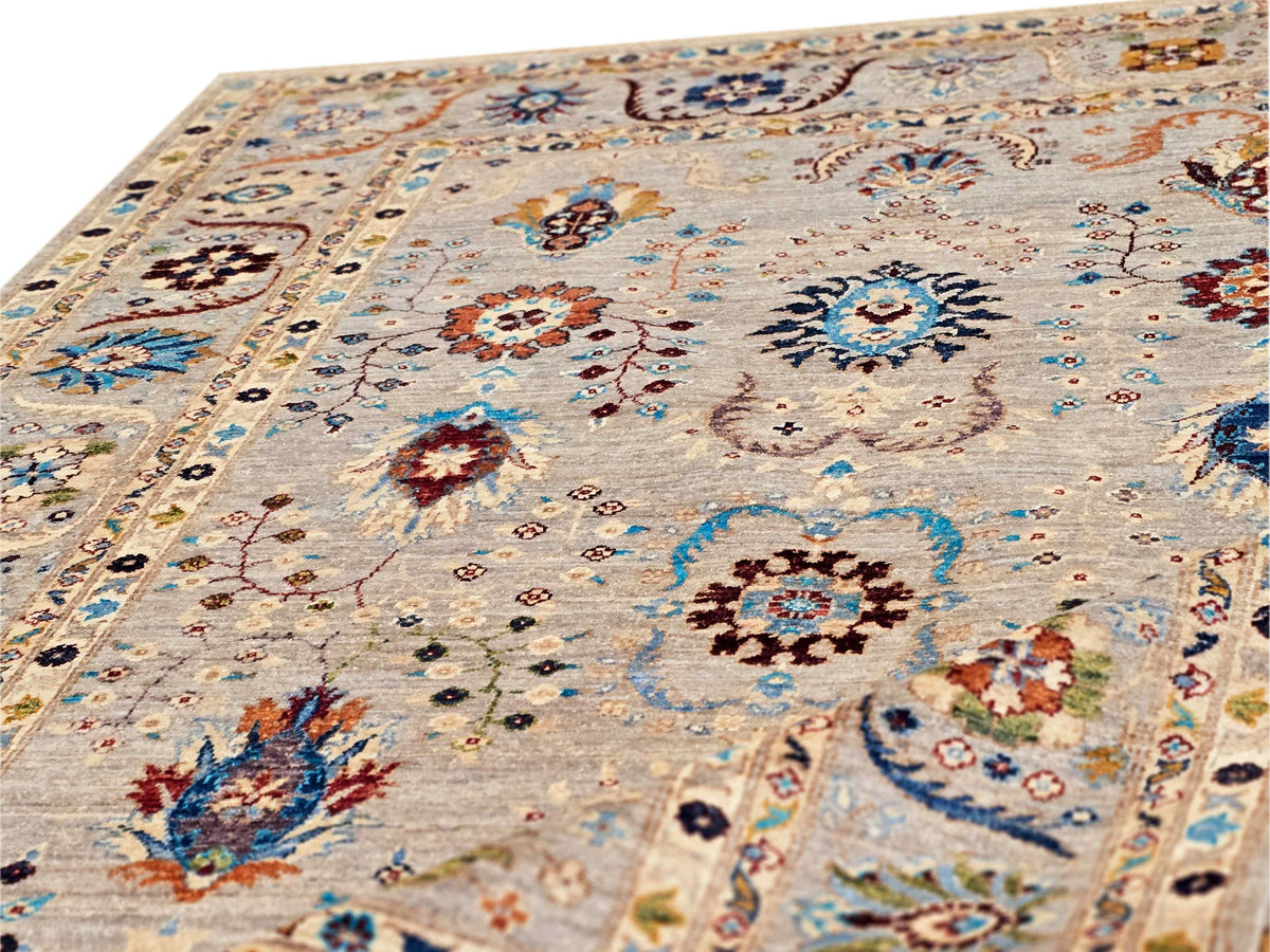 Light beige patterned area rug with circular medallions, blue accents, and short fringe