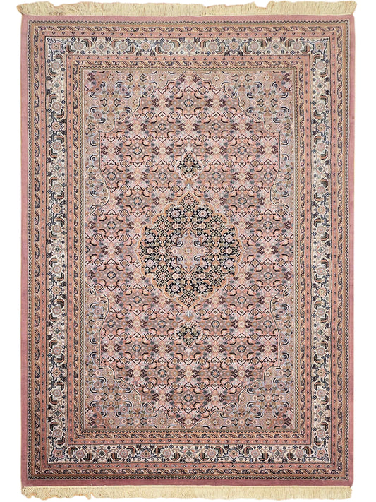 Bidjar rug front view with dusty rose frame, blue medallion center, and cream fringe
