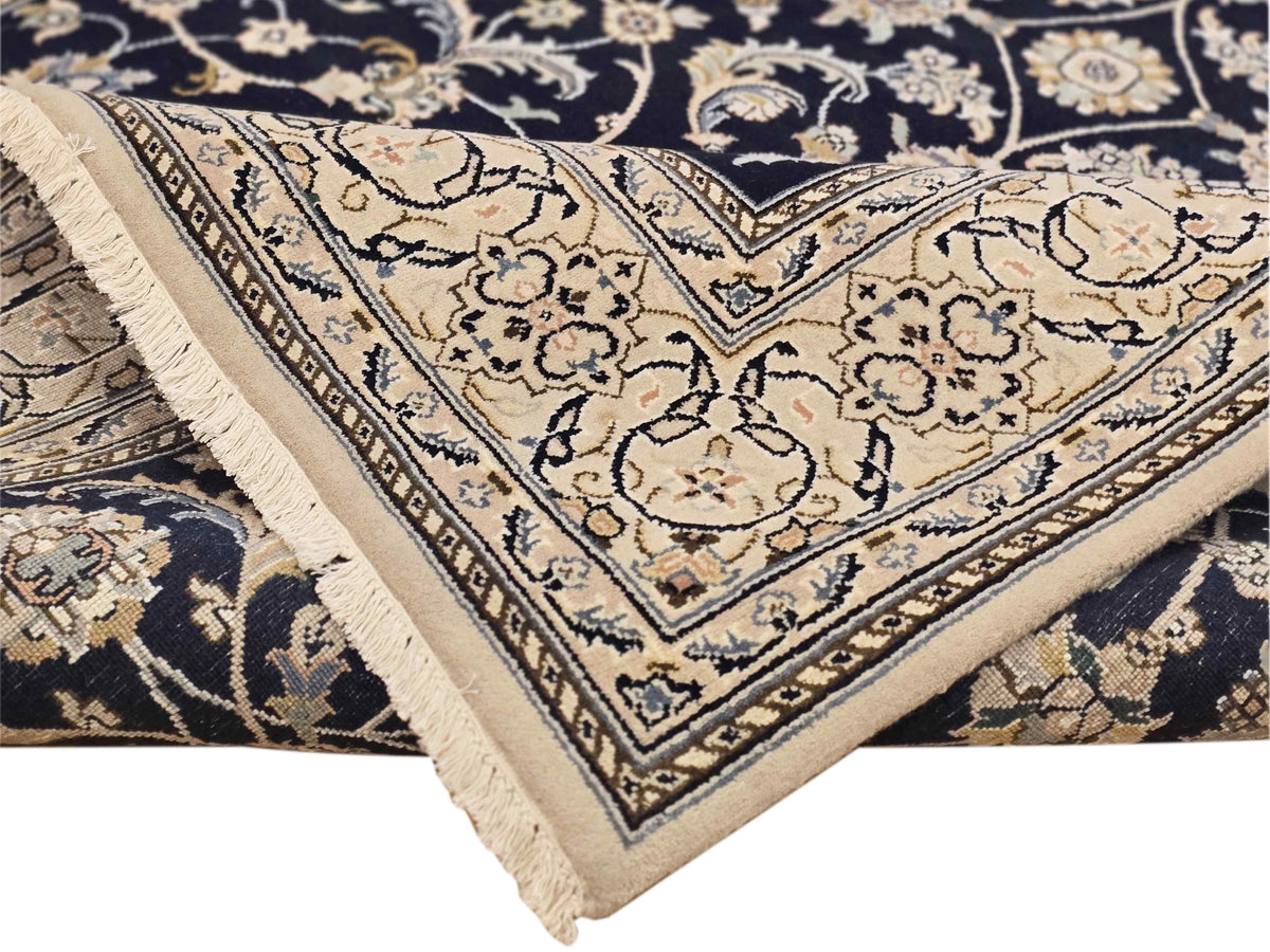 Navy Nain rug corner with cream floral medallion design and fringe trim