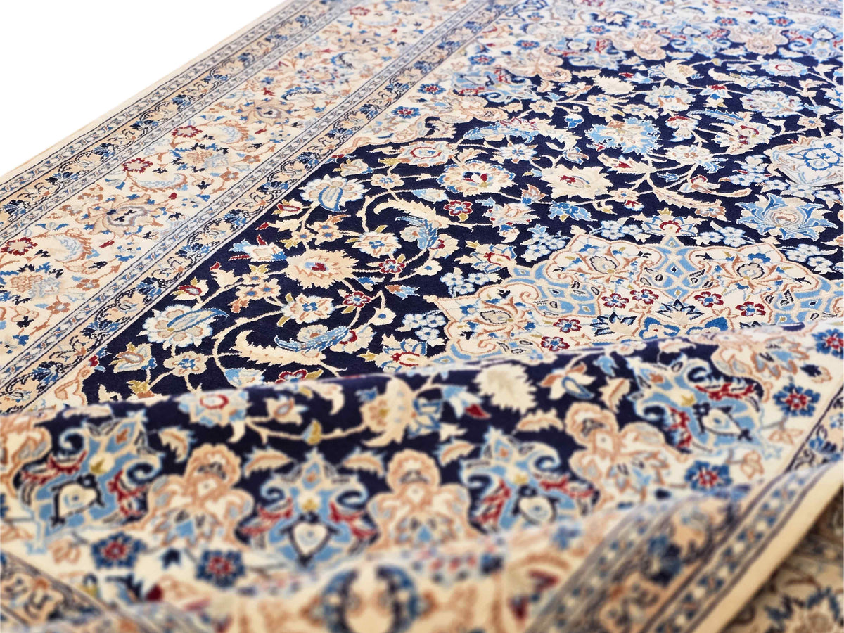 Close-up of Nain rug floral motif in navy blue with cream and tan accents.