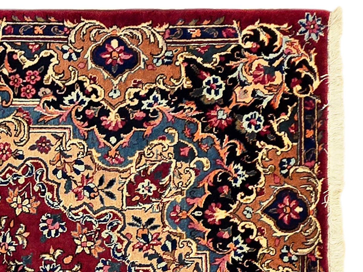 Close-up of rug border with floral scrollwork and trimmed light fringe