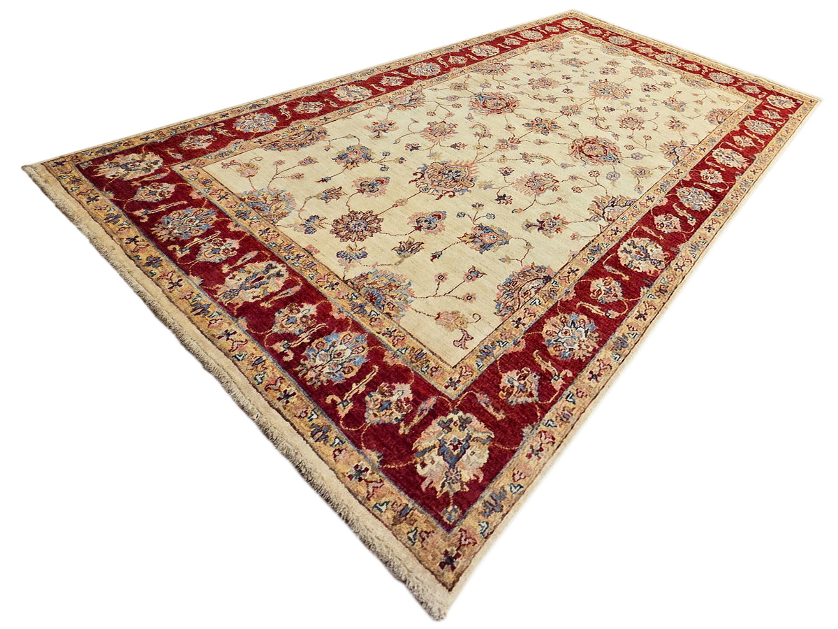 Traditional rug angled view with cream field, burgundy-red border, and floral details