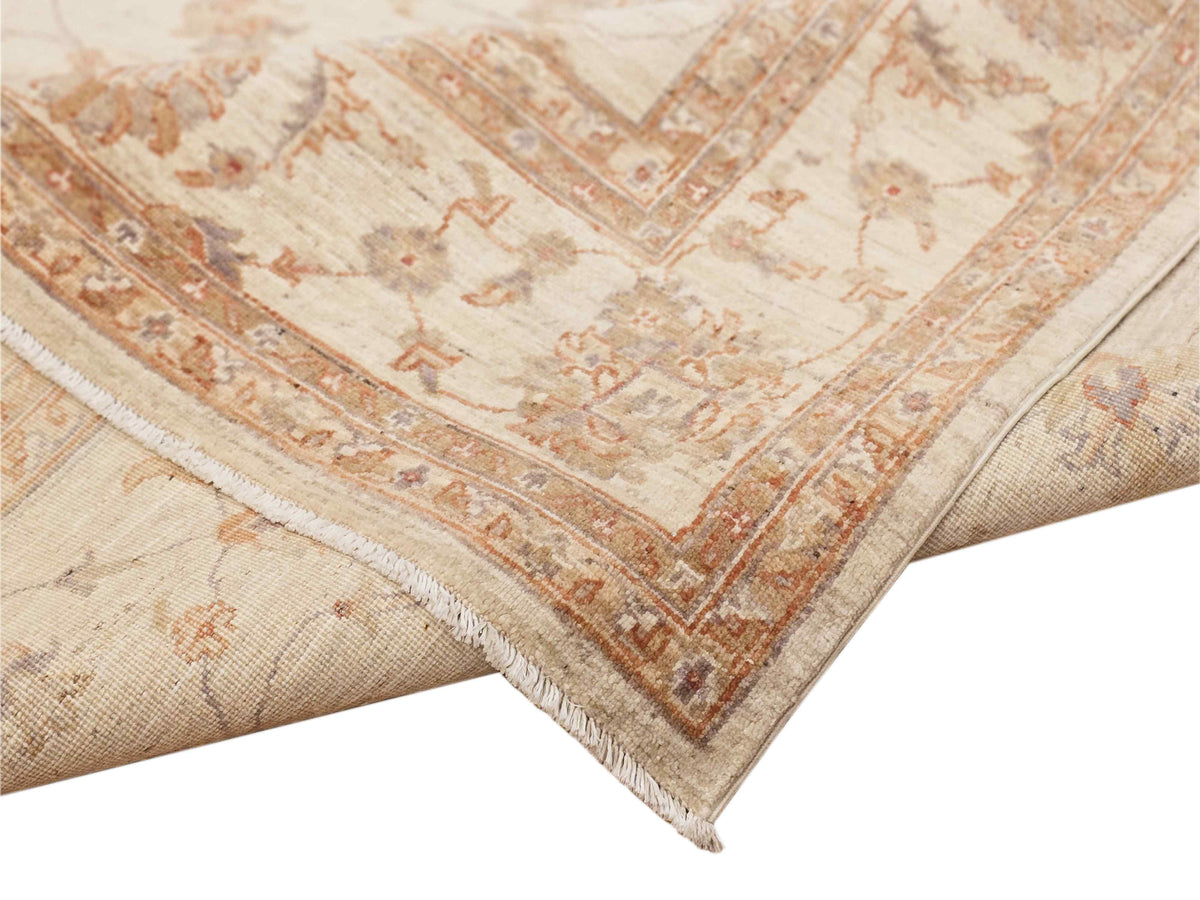 Rug corner with cream field, rust lattice border, and fringed edge detail.